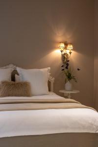 a bedroom with a bed with white sheets and a lamp at B&B 't Wit Huys Brugge in Bruges