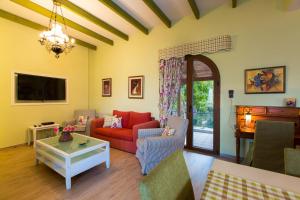 a living room with a red couch and a table at Beachfront Family Villa Katerina with Private pool, Playground, BBQ & Amazing Sea Views! in Petres