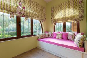 a pink bench in a room with windows at Beachfront Family Villa Katerina with Private pool, Playground, BBQ & Amazing Sea Views! in Petres
