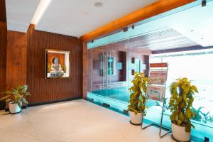 a swimming pool in a room with two potted plants at Sri Vishnu Grand in Vellore