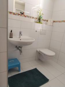 a white bathroom with a sink and a toilet at Apartmán Sofie in Poděbrady +2 photos