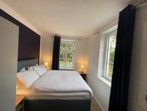a small bedroom with a bed with two windows at Fewo-meerblick-Rügen in Altefähr