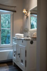 a bathroom with a sink and two windows at B&B 't Wit Huys Brugge in Bruges