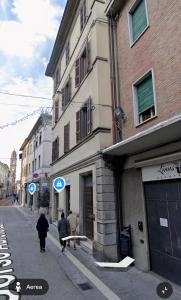 a person walking down a street next to a building at Appartamento Saffi in Faenza