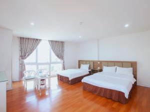 a hotel room with two beds and a table at Khách sạn Phúc Thành in Hanoi