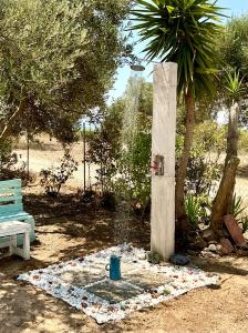 a water fountain in a park with a blue bench at Horizon House, with Olive Grove and a small Vineyard in Amarynthos
