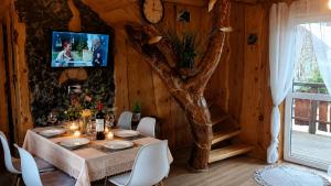 a dining room with a table and a tree at Bieszczadzka Chatka Gosia - Off Road , Quady , Jazda Konna in Czarna