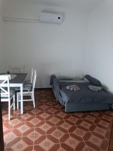 a bedroom with a bed and a table and a dining room at Azzurra Haven in Berchidda