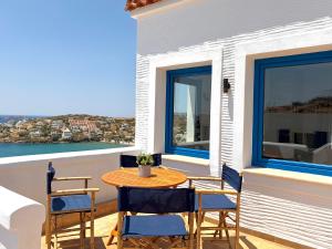 a table and chairs on the balcony of a house at Andros Villa in Andros