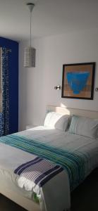 a bedroom with a bed with a striped blanket on it at Le chat bleu in Beauvoir-sur-Mer +12 photos