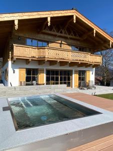 a house with a swimming pool in front of a building at Chalet am Wetterkreuz in Reit im Winkl