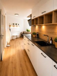 a kitchen with white cabinets and a sink at Schongau Suites Premium Apartments XL in Schongau