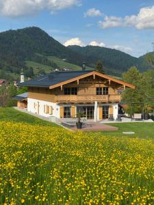 a building with a field of flowers in front of it at Chalet am Wetterkreuz in Reit im Winkl