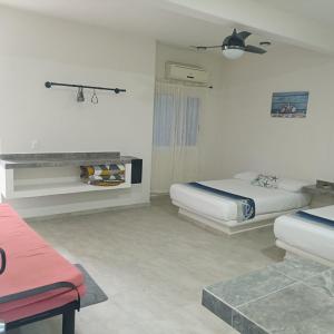 a white room with two beds and a couch at Casa Tania playa larga in Agua de Correa