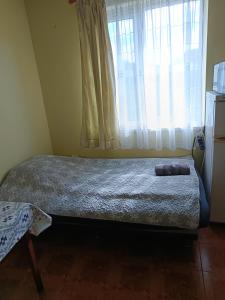a bed in a room with a window with curtains at VIP in Ahtopol