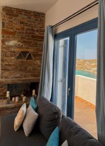 a living room with a leather couch and a window at Andros Villa in Andros