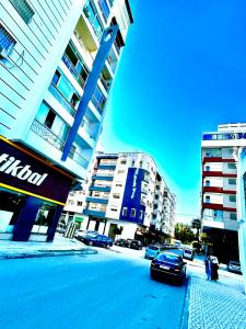a city street with cars parked in front of tall buildings at Man Wee Apprt in Tangier