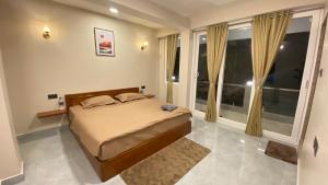 a bedroom with a bed and a large window at Stayat77 in Karsiyang