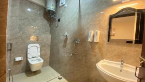 a bathroom with a toilet and a sink and a mirror at Stayat77 in Karsiyang