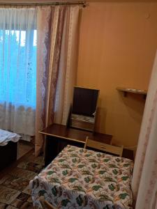 a bedroom with a bed and a desk and a window at Kwatery u Potoków in Piwniczna-Zdrój
