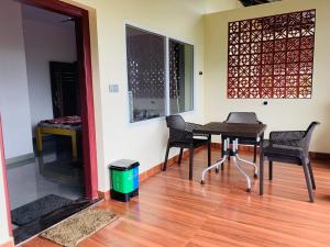 a dining room with a table and chairs on a wooden floor at Naisarga hill view homestay in Somvārpet