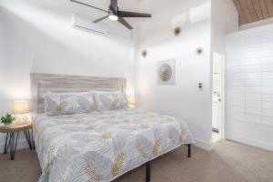 a bedroom with a bed and a ceiling fan at Modern-Rustic Beach Renovation Direct Oceanfront Penthouse in Kahana