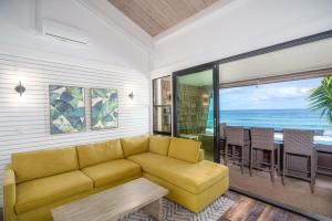 a living room with a yellow couch and a table at Modern-Rustic Beach Renovation Direct Oceanfront Penthouse in Kahana
