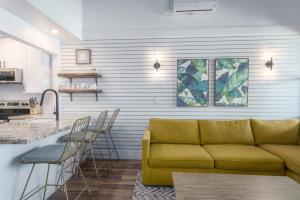 a living room with a yellow couch and a kitchen at Modern-Rustic Beach Renovation Direct Oceanfront Penthouse in Kahana +35 photos