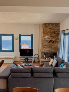 a living room with a couch and a tv at Andros Villa in Andros