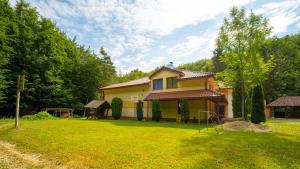 a yellow house in a yard with a grassy field at Chata Motocentrum in Snina