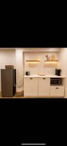 a kitchen with white cabinets and a black refrigerator at Modern private apartment - Warm atmosphere in Repentigny