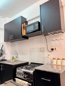 a kitchen with a stove and a microwave at Escape Reef in Watamu