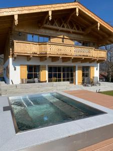 a house with a swimming pool in front of a building at Chalet am Wetterkreuz in Reit im Winkl