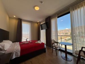 a bedroom with a bed and a table with a view at Hotel San Miguel Cusco in Cusco