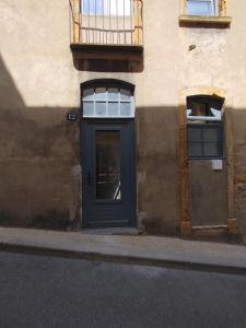 a building with a blue door and two windows at Trévoux centre appartement climatisé in Trévoux