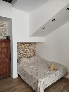 a bed in a room with a brick wall at Trévoux centre appartement climatisé in Trévoux