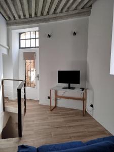 a living room with a television and a table at Trévoux centre appartement climatisé in Trévoux