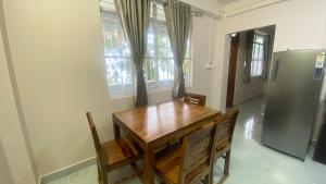 a dining room with a wooden table and a refrigerator at Stayat77 in Karsiyang +24 photos