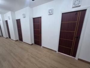 a row of doors in a room with wooden floors at Hotel Backpack BTS ปุณณวิถี in Bangkok +8 photos