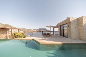 a villa with a swimming pool and a house at Asfiya Sea View Hotel in Kalkan