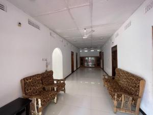 an empty hallway with two chairs in a building at ocean breeze in Challi