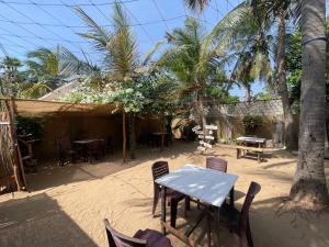 a table and chairs in a yard with palm trees at ocean breeze in Challi
