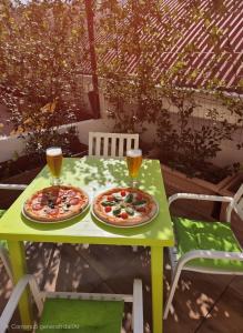two pizzas on a table with two glasses of beer at Elycon House Bergamo - Locazione turistica a camere in Bergamo