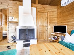 a living room with a fireplace and a tv at Holiday Home Naavarinne by Interhome in Muonio