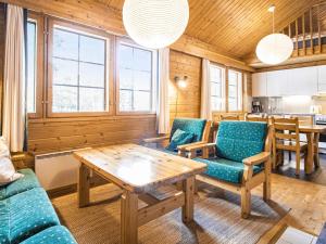 a living room with blue chairs and a wooden table at Holiday Home Naavarinne by Interhome in Muonio