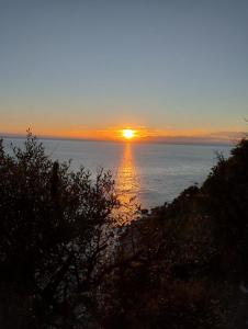 a sunset over the ocean with the sun setting at Terra Oliva in Vátos