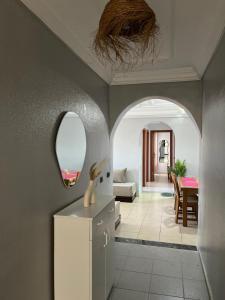 a hallway with a white refrigerator and a mirror at charmant appartement forêt et mer in Tangier