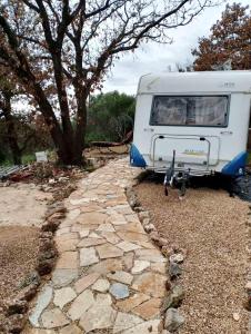 a white camper parked next to a stone path at Terra Oliva in Vátos