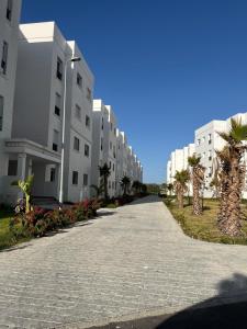 a cobblestone street in front of apartment buildings at charmant appartement forêt et mer in Tangier