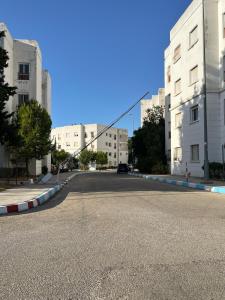 an empty street in a city with tall buildings at charmant appartement forêt et mer in Tangier +8 photos